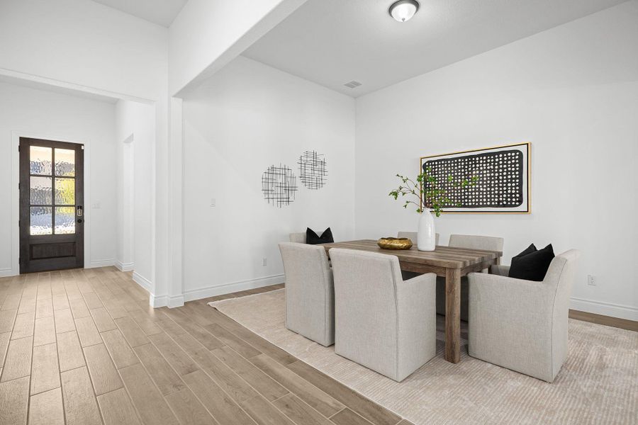 Dining room with light wood-type flooring and baseboards