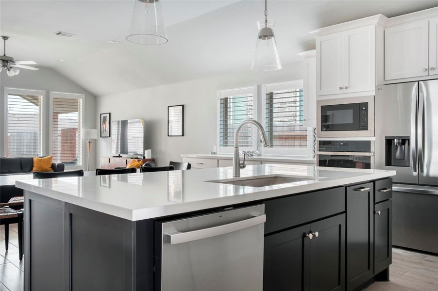 This photo showcases a modern, open-concept kitchen and living area. It features a large island with a sleek sink, stainless steel appliances, and ample cabinetry. The space is bright with natural light from multiple windows, and there's a cozy seating area with contemporary furnishings. This photo showcases a modern, open-concept kitchen and living area. It features a large island with a sleek sink, stainless steel appliances, and ample cabinetry. The space is bright with natural light from multiple windows, and there's a cozy seating area with contemporary furnishings.