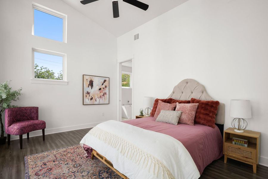 Sun-filled bedroom featuring a soaring vaulted ceiling and durable hardwood flooring. Sun-filled bedroom featuring a soaring vaulted ceiling and durable hardwood flooring.