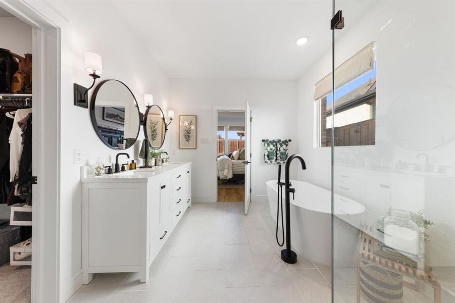 Primary bathroom with soaking tub, walk-in shower, double vanities, and generous closet space