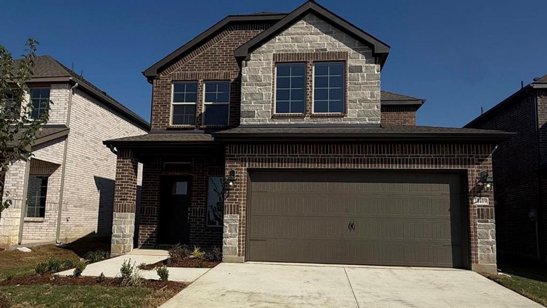 View of front facade with brick siding, driveway, a garage, and stone siding View of front facade with brick siding, driveway, a garage, and stone siding