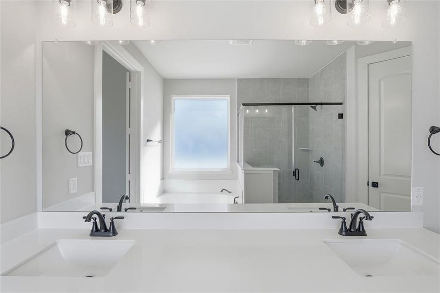 Full bathroom featuring a stall shower and double vanity