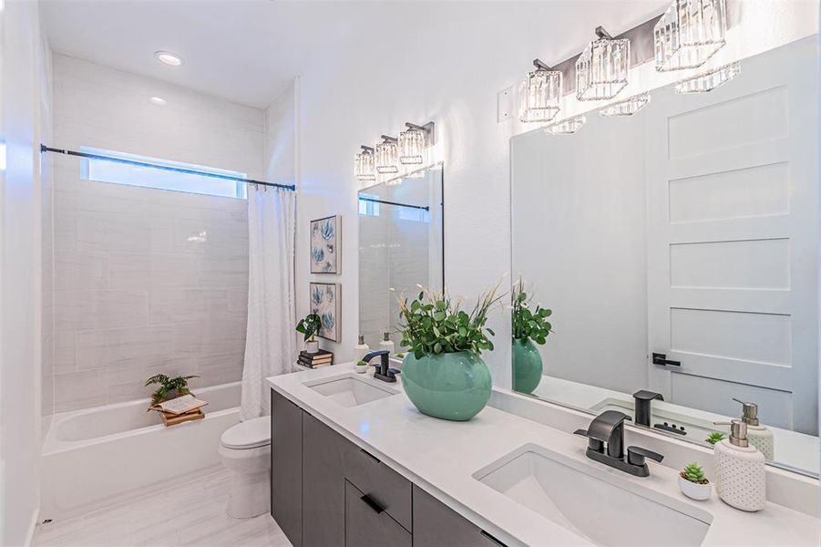 Bathroom featuring shower / tub combo, double vanity, and recessed lighting Bathroom featuring shower / tub combo, double vanity, and recessed lighting