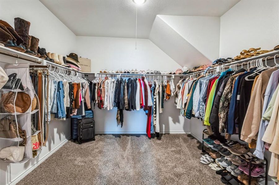 Spacious closet with vaulted ceiling and carpet flooring