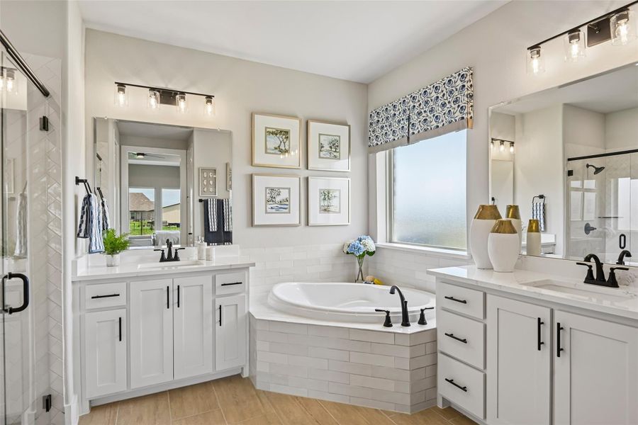 Master bathroom with dual vanities, corner soaking tub, white cabinets, and black fixtures Master bathroom with dual vanities, corner soaking tub, white cabinets, and black fixtures