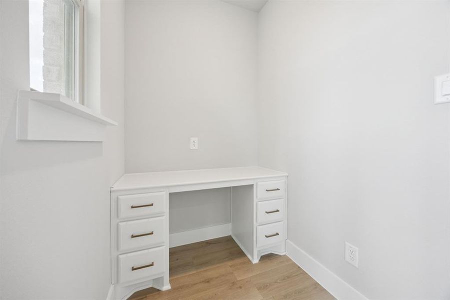 Unfurnished office with light wood-style floors and baseboards