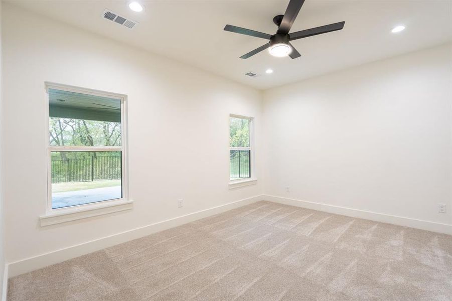 Spare room featuring light carpet and ceiling fan