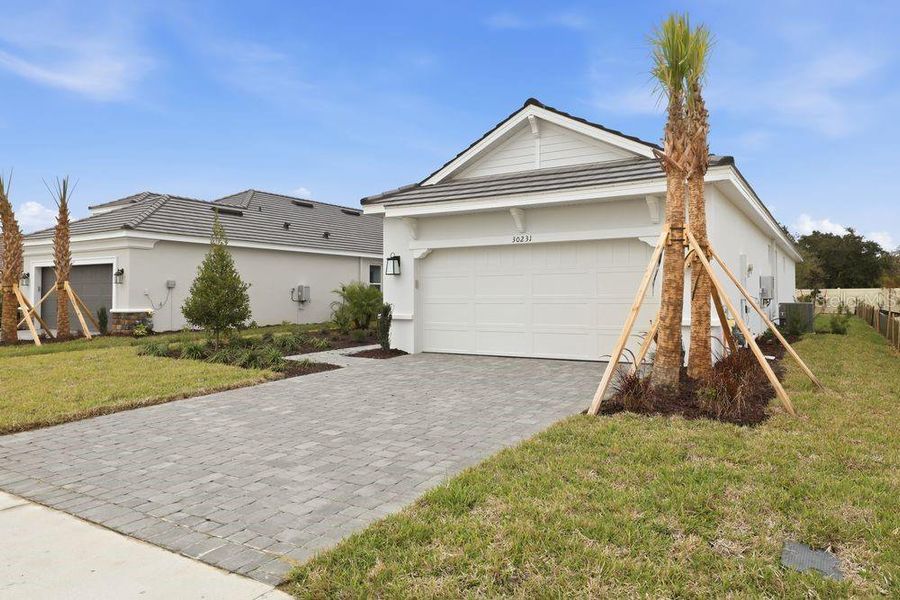Front exterior of a new home in Esplanade at Wiregrass Ranch, Wesley Chapel, FL, highlighting curb appeal (Image 1). Front exterior of a new home in Esplanade at Wiregrass Ranch, Wesley Chapel, FL, highlighting curb appeal (Image 1).