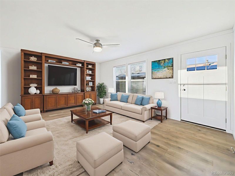 Family Room Virtually Staged A welcoming front living room complete with large windows, ceiling fan, and space for media cabinet—perfect for relaxing or entertaining.
