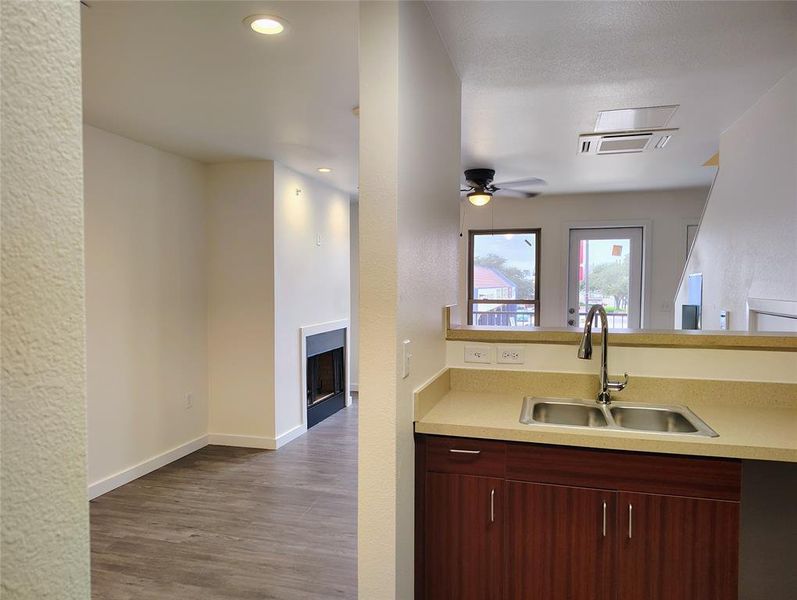 Kitchen with ceiling fan, wood-type flooring, and sink