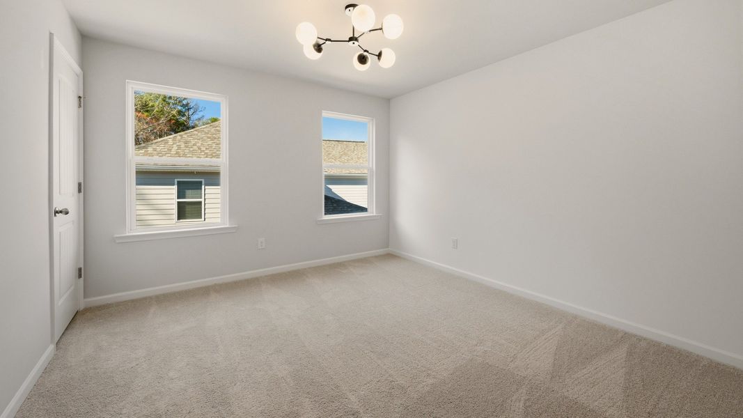 Bedroom with bright natural lighting from windows and carpet Bedroom with bright natural lighting from windows and carpet
