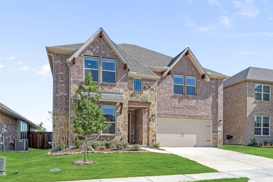 Two-story home with brick and stone exterior, two-car garage, and manicured front lawn Two-story home with brick and stone exterior, two-car garage, and manicured front lawn