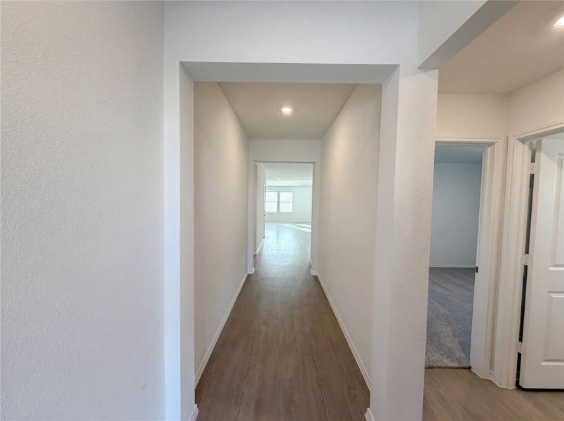 Corridor featuring wood finished floors and recessed lighting