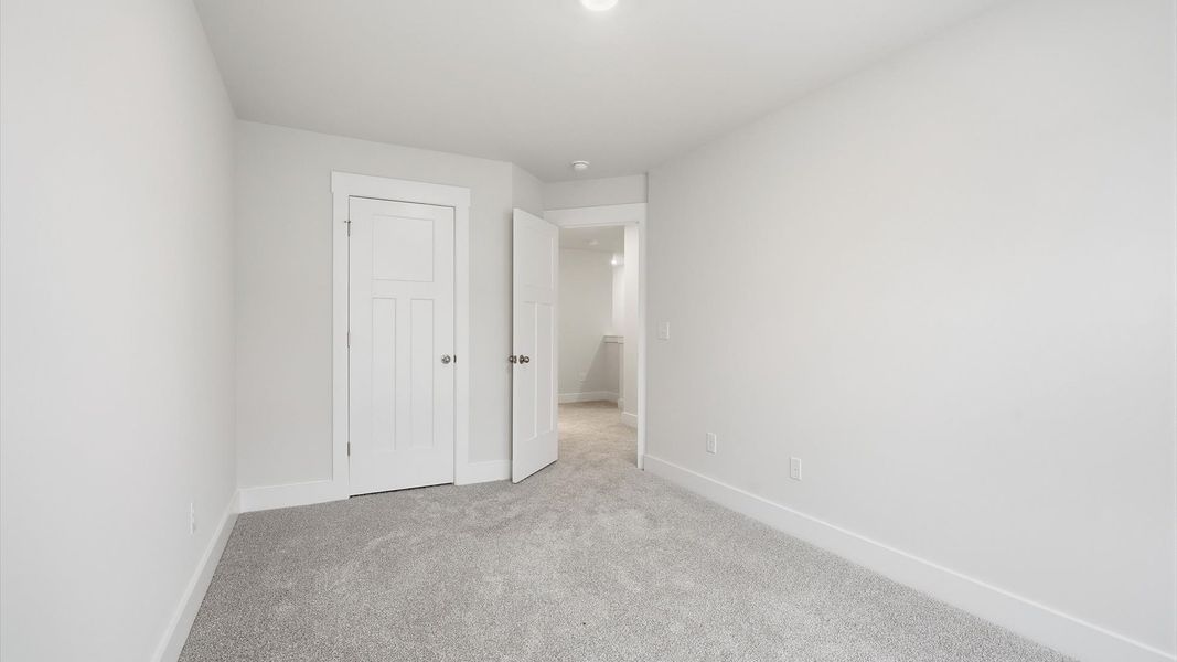 Superior comfort in a secondary bedroom with plush carpet and an oversized walk-in closet by DRB Homes