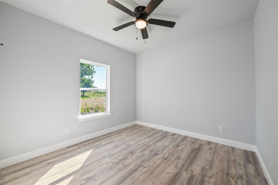 Empty room featuring wood finished floors and ceiling fan Empty room featuring wood finished floors and ceiling fan
