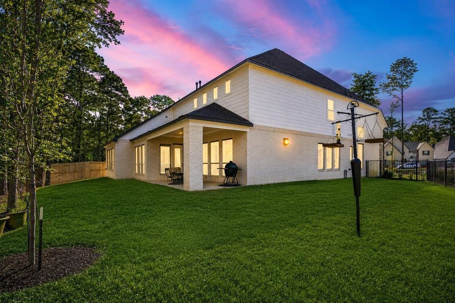 This spacious backyard with a covered patio is perfect for outdoor dining and relaxation.