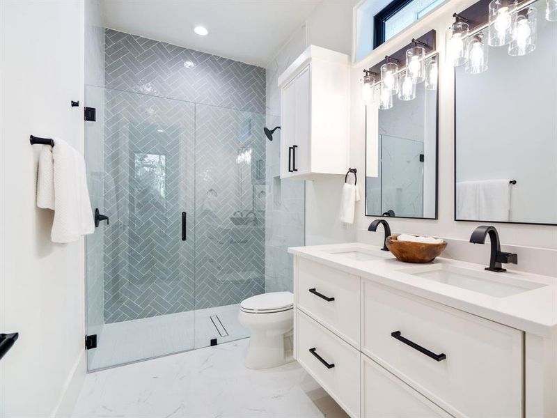 Bathroom with double vanity, a shower stall, and recessed lighting