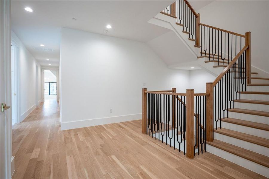 Staircase featuring lofted ceiling and hardwood / wood-style floors