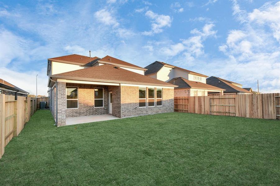 Discover the charm of this spacious backyard featuring a delightful covered patio. Sample photo of completed home with similar floor plan. As-built interior colors and selections may vary.