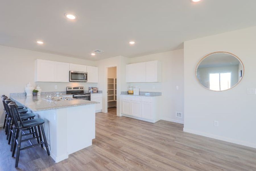 A kitchen with white cabinets.