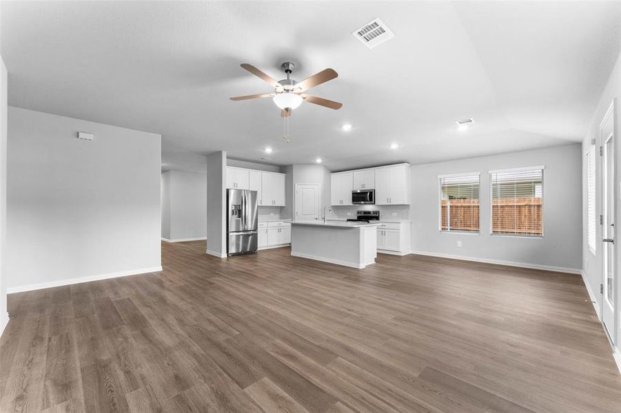 Unfurnished living room with a ceiling fan, recessed lighting, wood finished floors, and lofted ceiling. REFRIGERATOR INCLUDED Unfurnished living room with a ceiling fan, recessed lighting, wood finished floors, and lofted ceiling. REFRIGERATOR INCLUDED