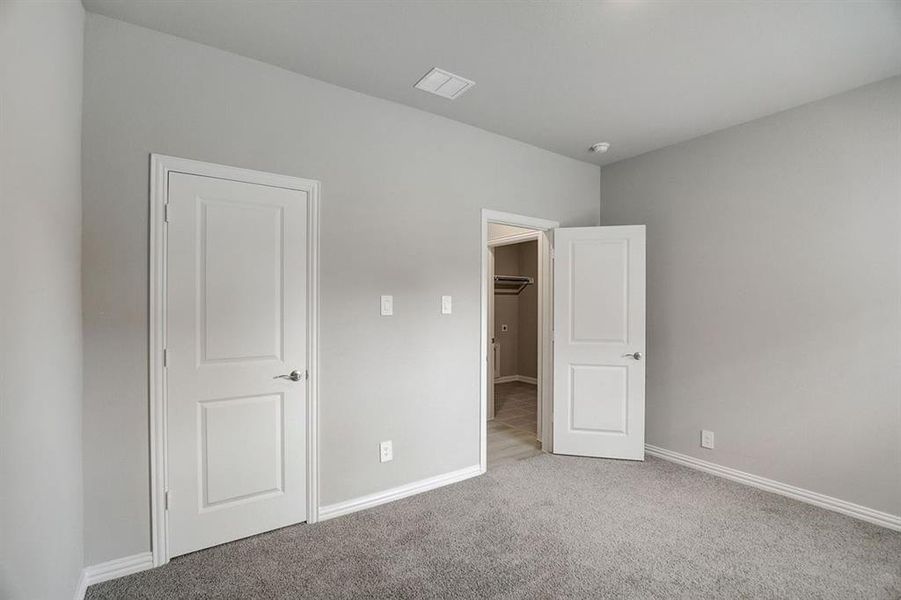 Unfurnished bedroom featuring light carpet and a closet