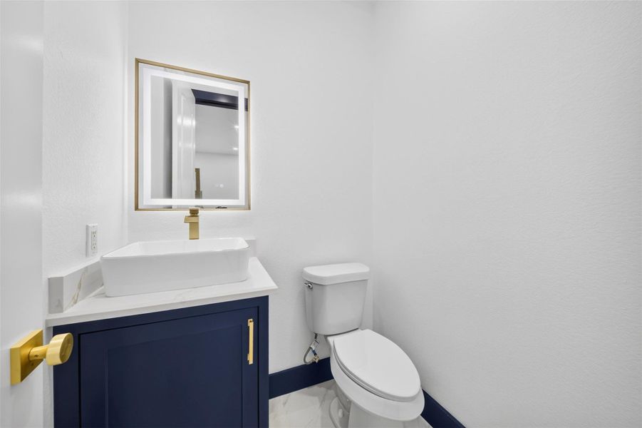 Convenient half bath with contrasting vanity and clean contemporary finishes