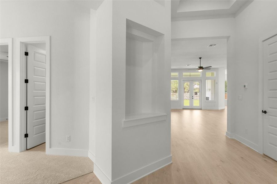 Hallway featuring light wood finished floors and french doors Hallway featuring light wood finished floors and french doors