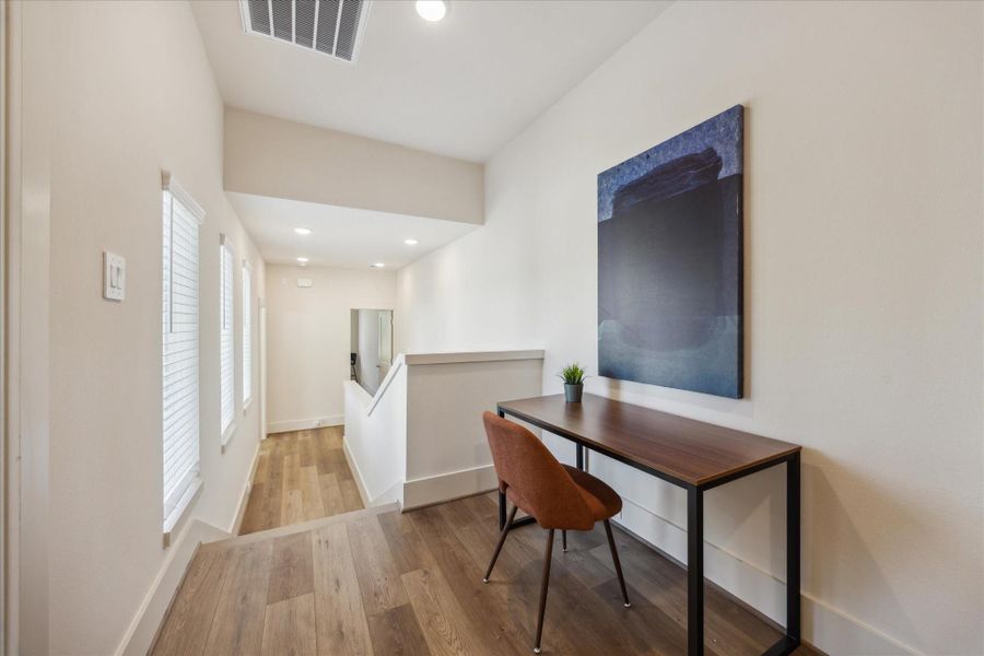 With abundant natural light from the adjacent windows and warm wood flooring underfoot, it’s a bright and inspiring spot to focus, create, or simply enjoy a quiet moment.