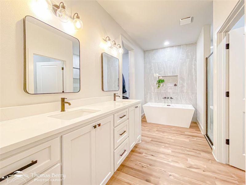 Primary ensuite bathroom with dual sinks and storage.