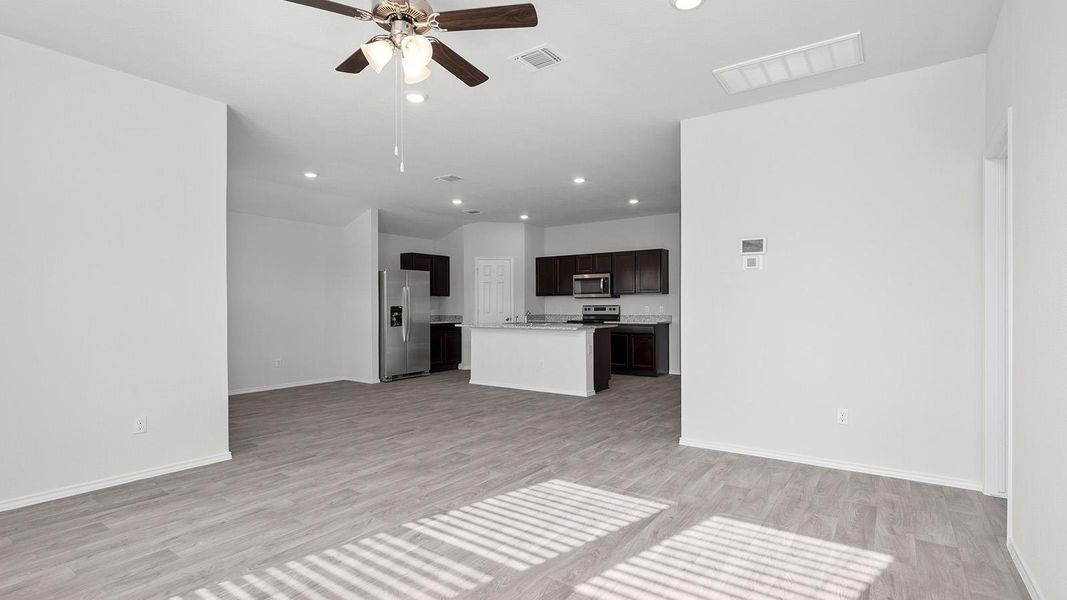 Unfurnished living room with a ceiling fan, recessed lighting, and light wood-style floors