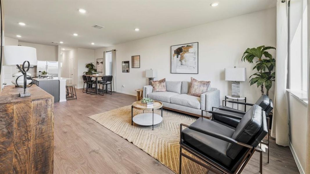 Living area with light wood-style flooring and recessed lighting