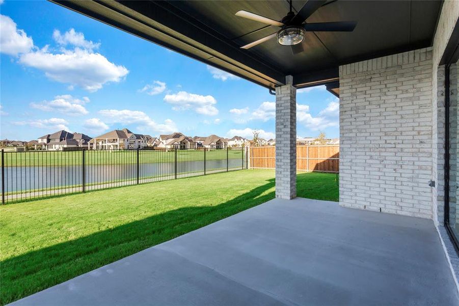 Fenced backyard with a water view, a residential view, a patio area, and ceiling fan