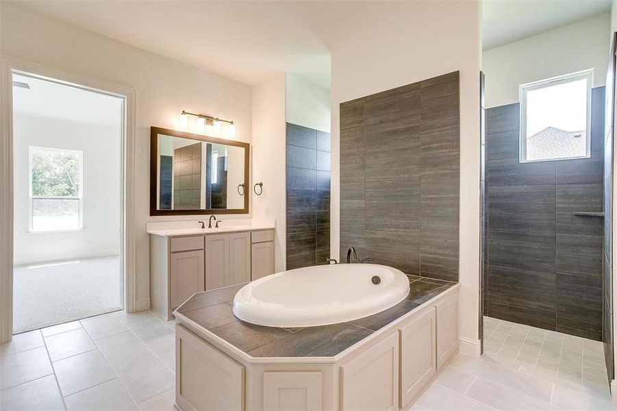 Bathroom featuring independent shower and bath, vanity, and tile patterned flooring