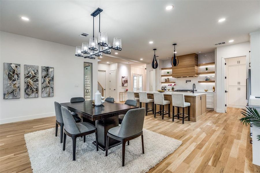 Dining room featuring sink, light hardwood / wood-style floors, and an inviting chandelier