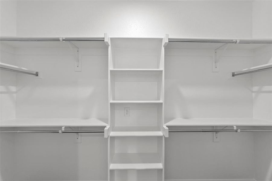 Custom closet system featuring multiple shelving units and ample hanging space