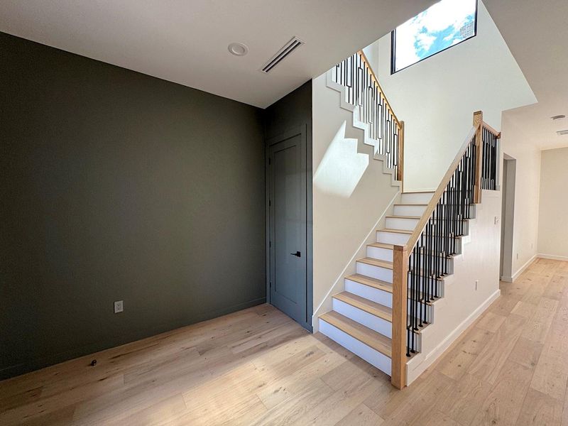 Staircase with visible vents, baseboards, and wood finished floors