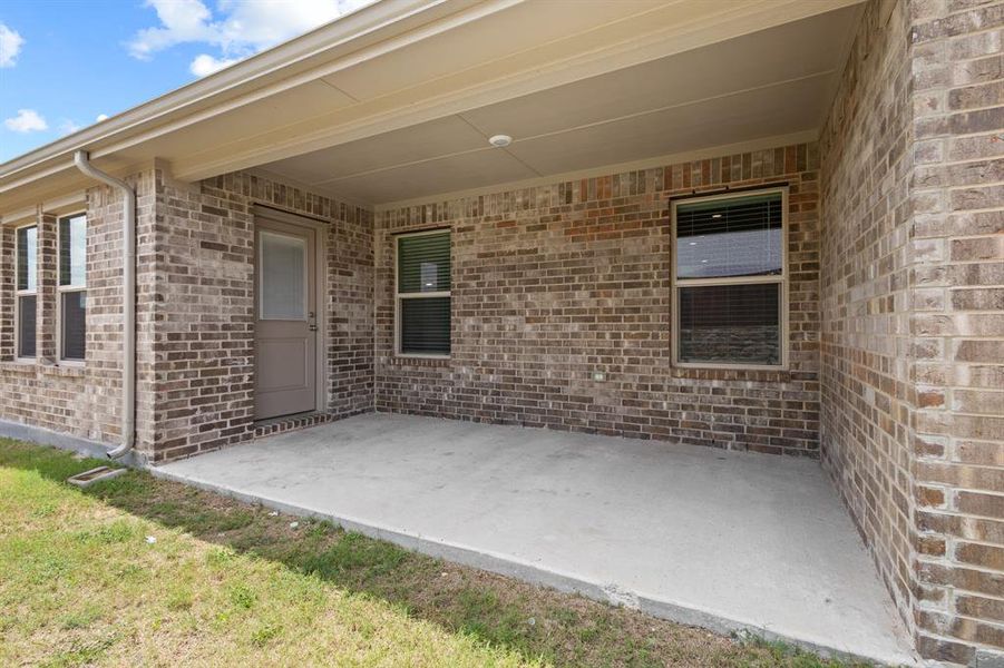 Covered patio featuring a concrete slab and a brick exterior Covered patio featuring a concrete slab and a brick exterior