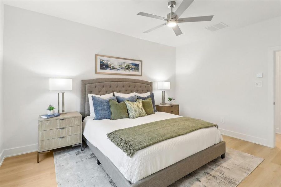 Bedroom featuring a ceiling fan, baseboards, visible vents, and light wood finished floors