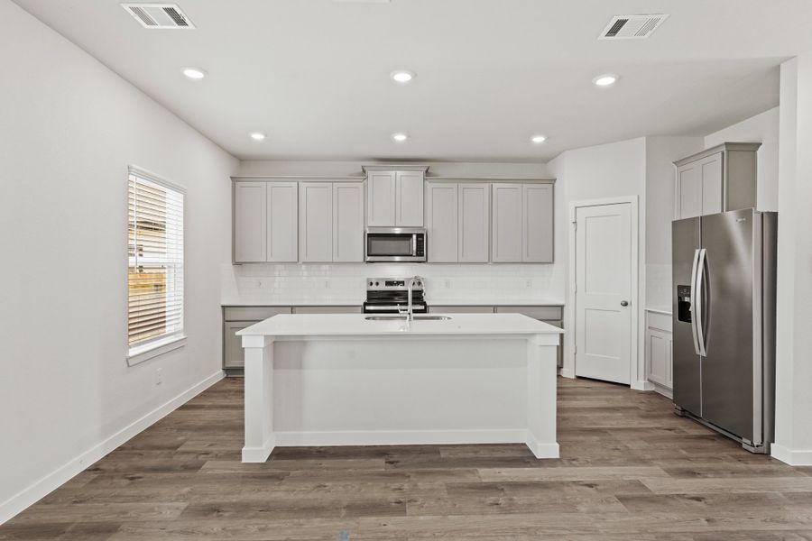 A kitchen with white cabinets.