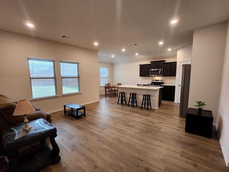 Living area featuring recessed lighting and dark wood-style flooring