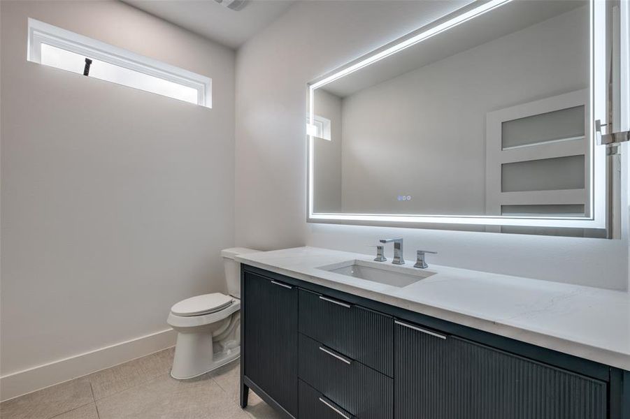 Half bathroom featuring vanity and light tile patterned flooring