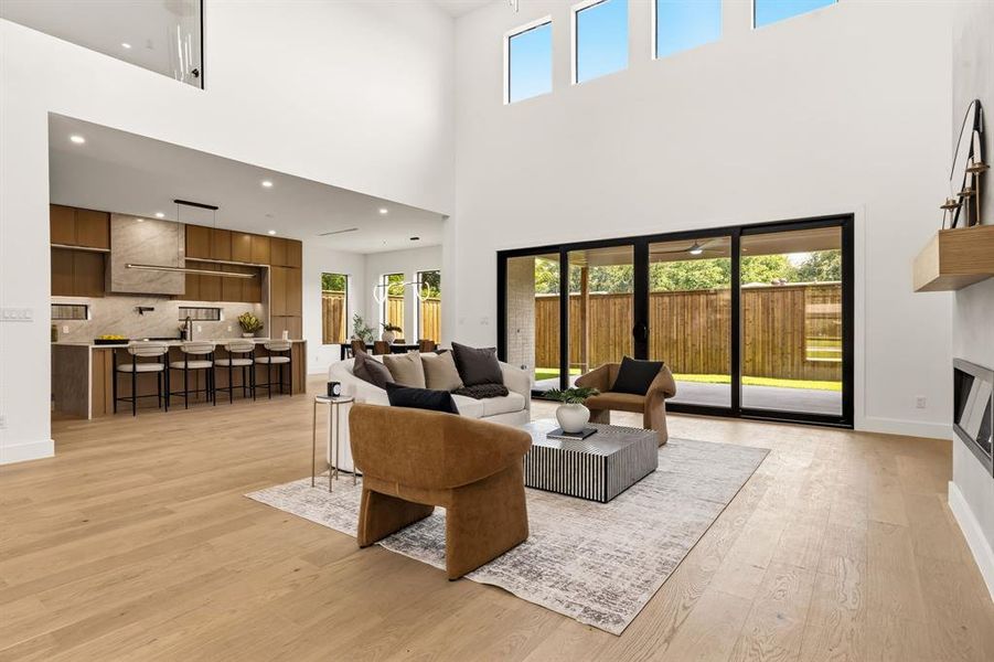 Vaulted living area featuring wood-finish flooring, a linear fireplace, and a sliding glass door
