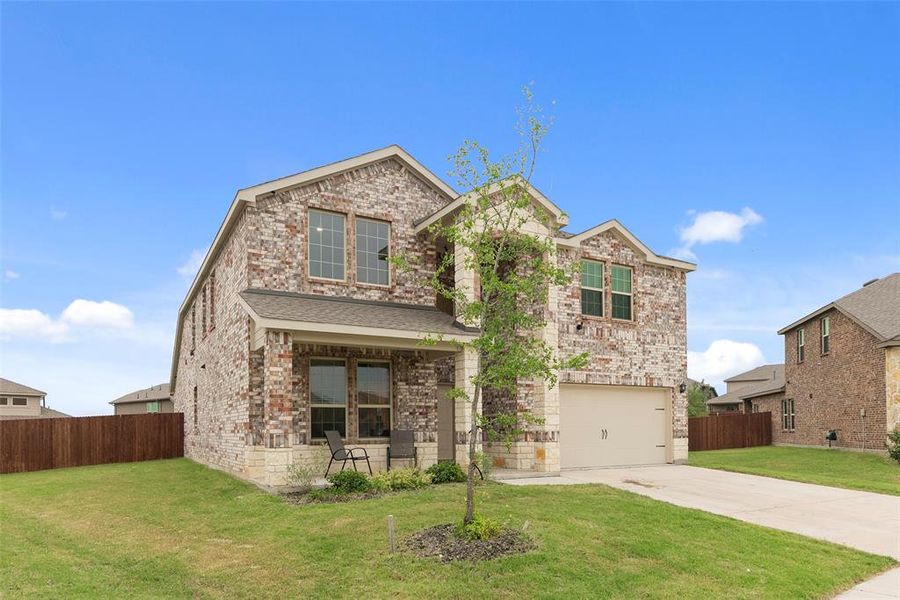 Two-story residence featuring a mixed brick and stone facade, an attached garage, and a covered front porch