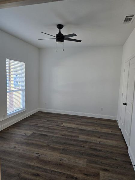 Spare room with dark wood-style flooring and a ceiling fan