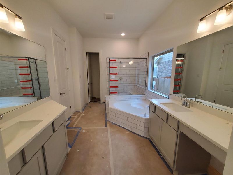 Bathroom with vanity, concrete floors, and separate shower and tub