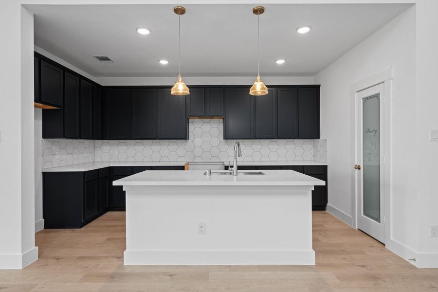 Every detail has been thoughtfully designed, from the pantry and nice-sized island that make meal prep a breeze, to the charming backsplash that adds a touch of personality.