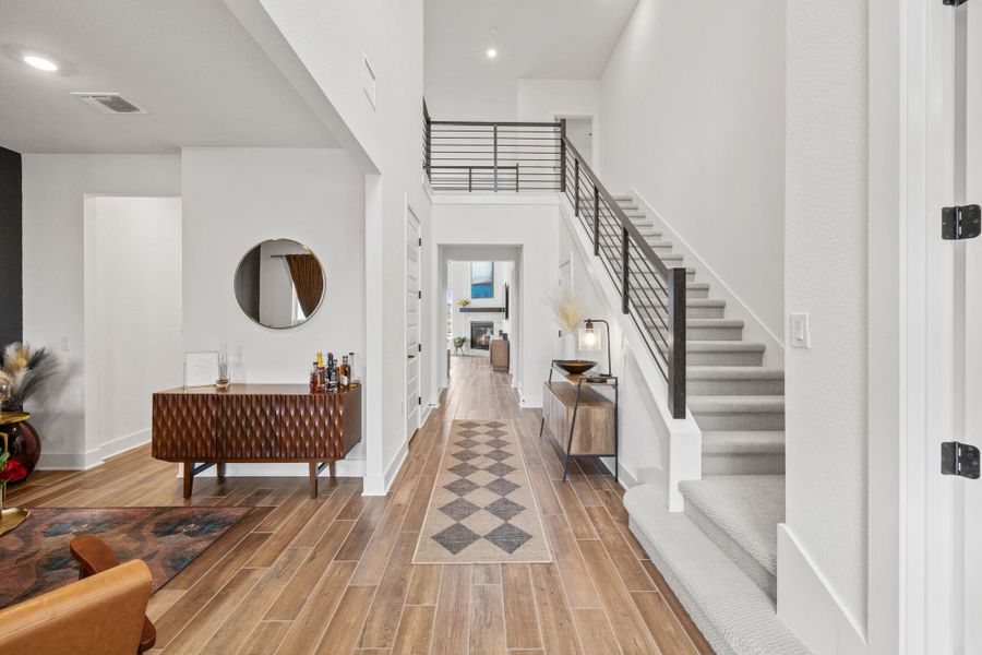 Entrance foyer featuring tiled floors, stairway, and a high ceiling