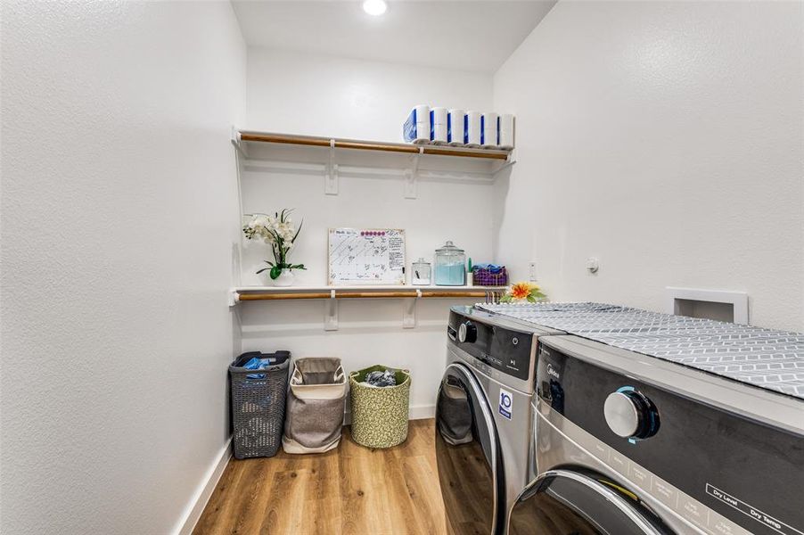 Washroom with light wood finished floors and separate washer and dryer