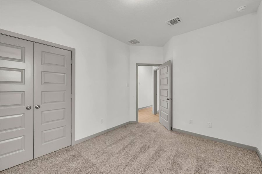 Unfurnished bedroom with a closet and light colored carpet